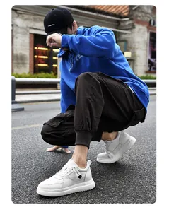 Detail view of men's white leather sneakers with 8cm hidden height increase in street scene