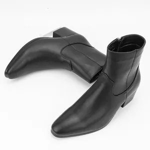 Vista lateral de los elegantes botines negros de tacón alto para hombre con punta fina.