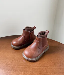 Primer plano de botas tipo Martin para niña en color marrón con detalles brogue