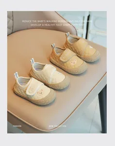 Dettaglio di scarpe primi passi morbide per bambine con ricamo a forma di orso.
