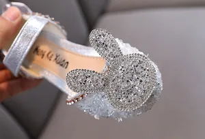 Close-up of silver rhinestone princess shoes with cute bunny ears for girls