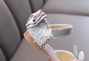 Detailed view of silver girl's princess shoe with satin bow and sparkling rhinestones.