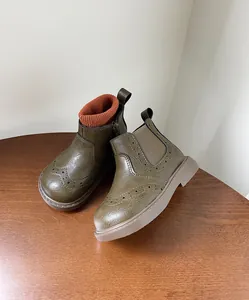 Detalle de botines brogue retro británicos verde oliva para niña con puño de punto naranja