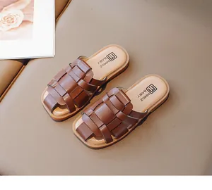 Primer plano de sandalias trenzadas marrones para niñas con diseño de correas transpirables