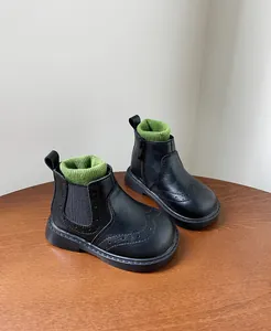 Vista detallada de botas negras para niños con cuellos de punto verde y brogue