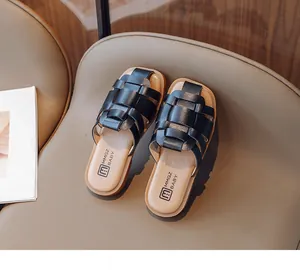 Primer plano de elegantes sandalias trenzadas negras para niñas con suela plana cómoda