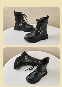 Detailed view of black kids' Martin boots with a floral buckle and thick rubber sole
