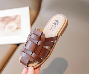 Detalle de sandalias tejidas marrones para niñas pequeñas con plantilla beige