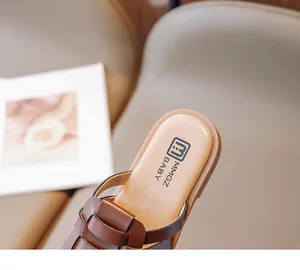 Detalle de sandalias de cuero trenzado marrón para niños con logo MMGZ BABY en la suela