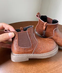 Primer plano de botas de cuero marrón para niños de estilo retro con detalles brogue
