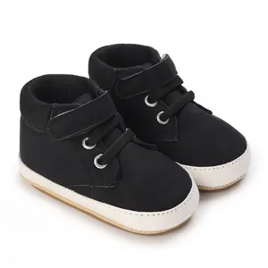 Klassische schwarz-weiße Lauflernschuhe mit weicher Sohle für Babys, ideal für erste Schritte.