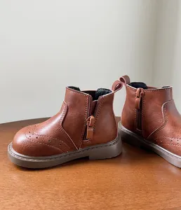 Vista lateral de botas de cuero retro marrón para niñas pequeñas con cremallera y detalles brogue