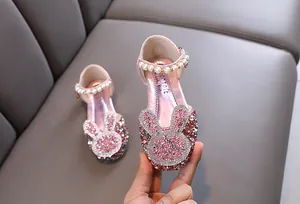 Detailed view of pink glitter girl's shoes with rhinestone bunny and pearl strap