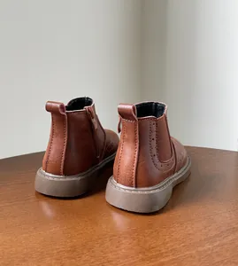 Vista trasera de botines Chelsea clásicos de cuero marrón para niños con cremallera lateral