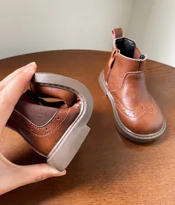 Detalle de la suela blanda y flexible de las botas de cuero marrón para niños