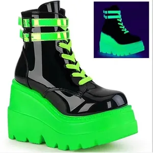 Gros plan de bottines à plateforme vert néon montrant l'effet phosphorescent au noir