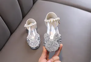 Close-up of sparkling silver girls' princess shoes with rhinestone bunny detail
