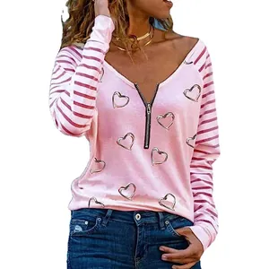 Dettaglio ravvicinato maglia rosa donna con stampa a cuore e cerniera frontale.