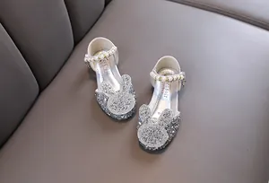Close-up of sparkly silver girls' princess shoes with rhinestone bunny and pearl strap