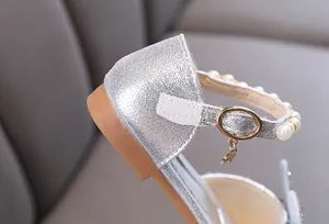 Detailed view of silver girls princess shoe with pearl strap and gold buckle