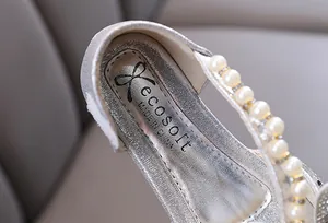 Detail view of silver girls' princess shoe featuring a pearl strap and brand logo inlay