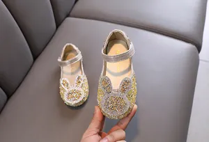 Detailed view of sparkling gold girls' princess shoes featuring a rhinestone bunny motif