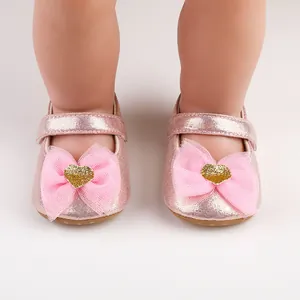 Nahaufnahme von rosa glitzernden Baby-Prinzessinenschuhen mit Netzschleifen und Herzen.