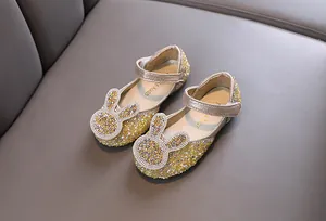 Detailed macro shot of sparkly gold glitter toddler girls princess shoes with rabbit decor
