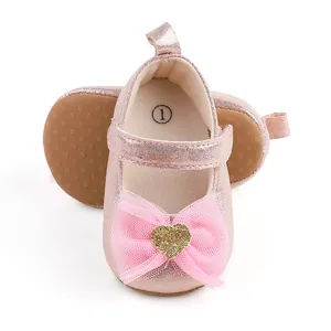 Detail von rosa metallic Mädchen-Prinzessin-Schuhen mit Netzschleife und Glitzerherz.