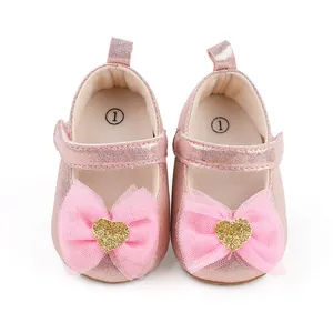 Nahaufnahme von rosa Baby-Prinzessinenschuhen mit Netzschleife und Herzdetail.
