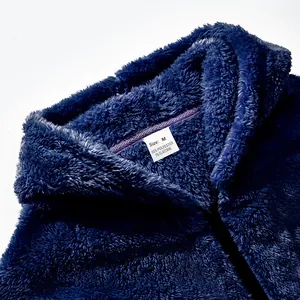 Gros plan sur la texture d'une veste à capuche en polaire bleu marine avec étiquette