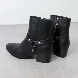 Vue latérale de bottines en cuir noir avec bout pointu et détail de boucle argent
