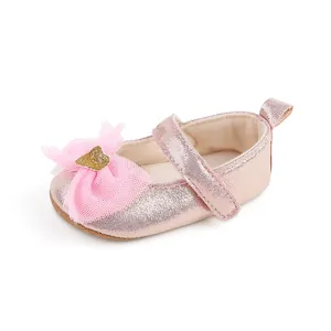 Detailansicht der glitzernden Textur und der rosa Netzschleife am Babyschuh für Mädchen