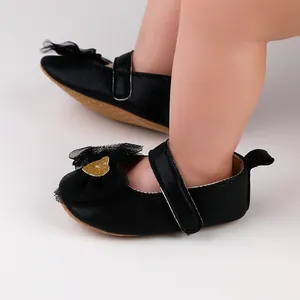 Detailansicht von schwarzen Baby-Prinzessin-Schuhen mit Netzschleife und goldenem Glitzerherz