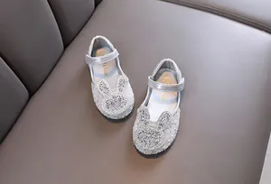 Detail view of sparkly silver girl's princess shoes with a rhinestone bunny design.
