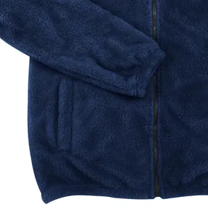 Gros plan sur le tissu polaire bleu et le détail de la fermeture éclair de la veste homme.