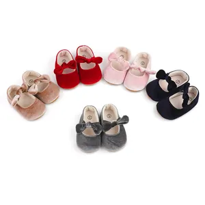 Close-up detail of several pairs of velvet baby girl princess shoes in various colors