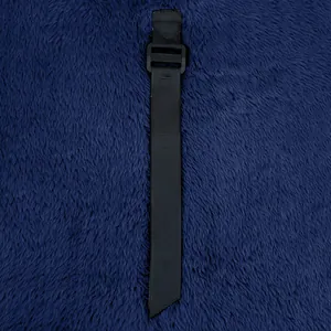 Macro view of black nylon strap with plastic buckle on textured blue polar fleece fabric