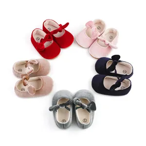 Close-up of colorful velvet baby princess shoes with bows arranged in a neat circle.