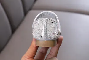Close-up of sparkling rhinestones and pearls on the heel of silver princess shoes
