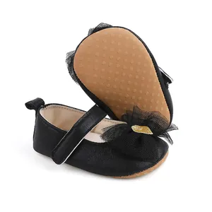Detailansicht von Baby-Prinzessin-Schuhen mit schwarzer Netzschleife und rutschfester Sohle