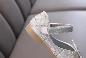 Detailed macro view of silver glitter girls princess shoes with pearls and shiny rhinestones