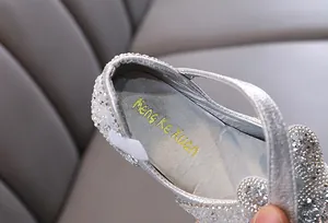 Close-up of silver sparkling girls' princess shoes with pearl and crystal details