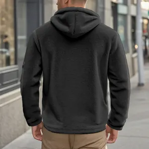 Back view detail of a men's black fleece winter hooded jacket on an urban street