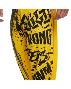 Close-up detail of yellow quick-dry gym sports pants with bold black graffiti print