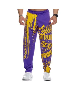 Full-length view of men's purple joggers with bold yellow graffiti prints for fitness