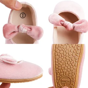 Detalle de zapatos de princesa de terciopelo rosa para bebé con suela antideslizante