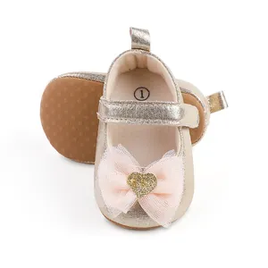 Detailansicht goldener Babyschuhe für Mädchen mit rosa Schleife und Glitzerherz