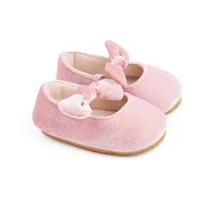 Detail view of pink velvet baby princess shoes with soft bow decoration.