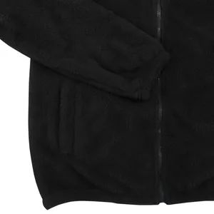 Détail du matériau en polaire noire douce sur une veste d'hiver à fermeture éclair